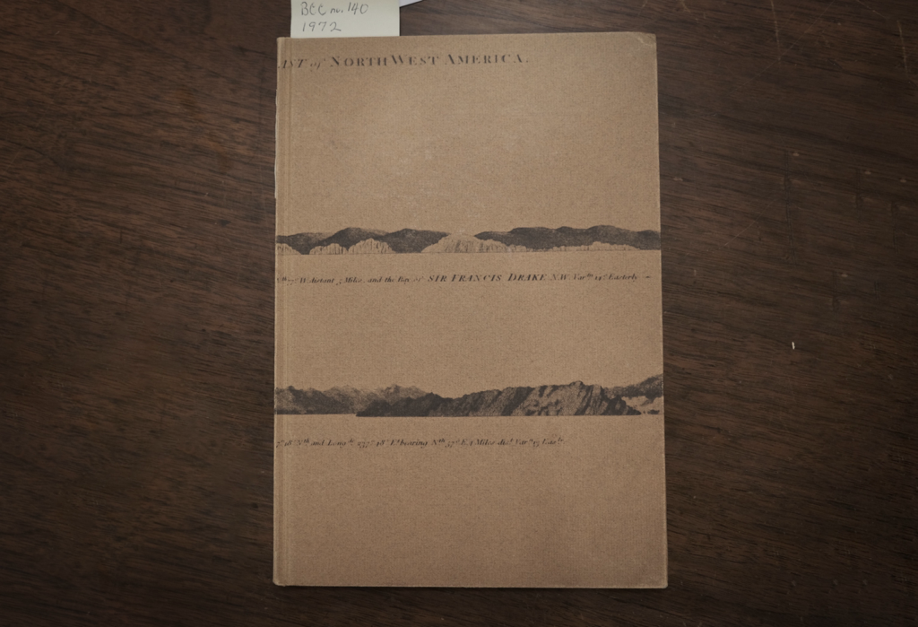 A beautiful book in light brown with two mountain ranges illustrated in the middle